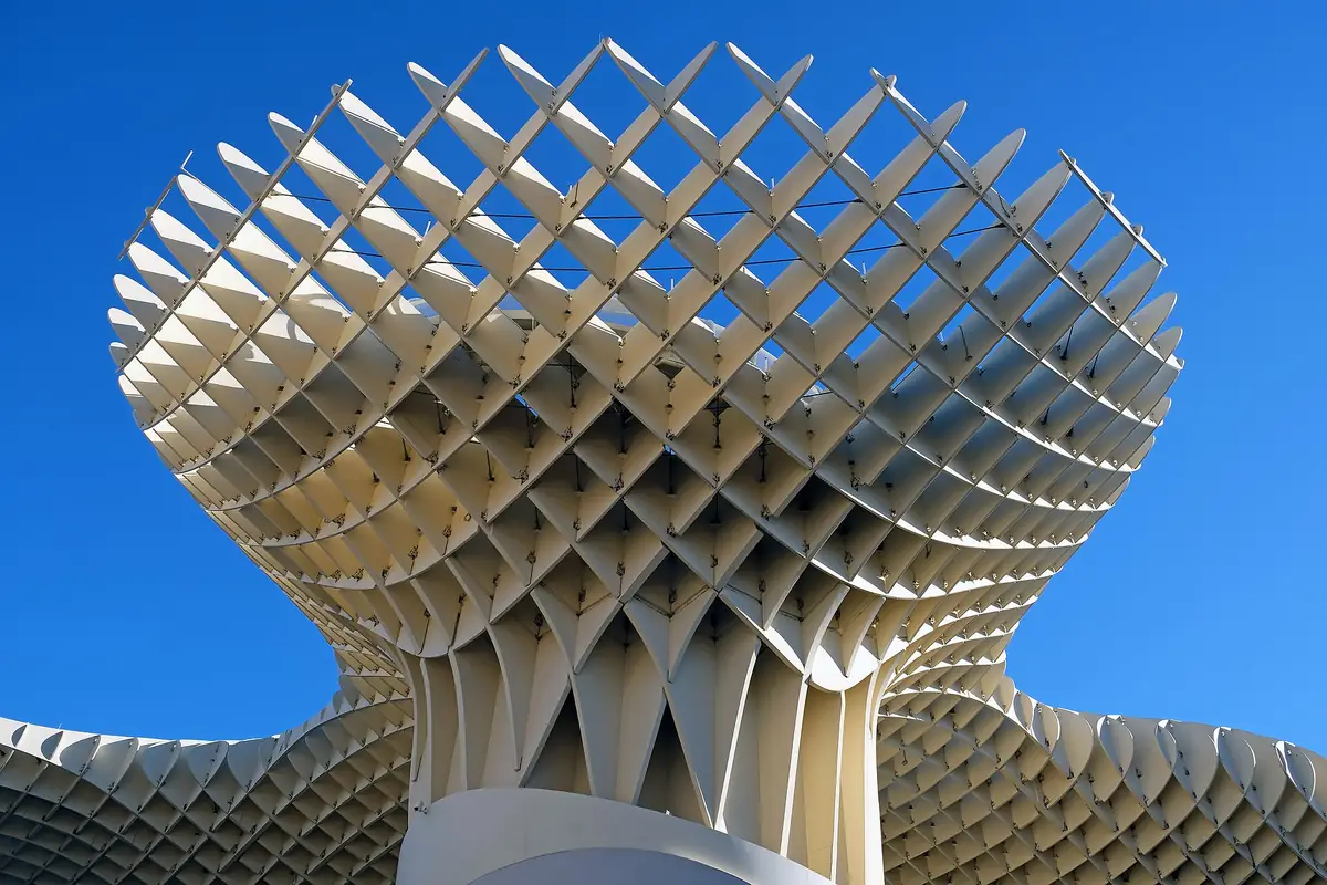 The white wooden lattice of the Metropol Parasol rising against a deep blue sky in Seville